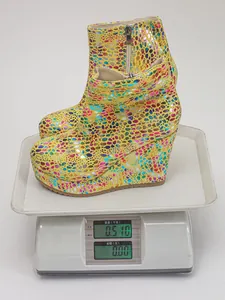 Detail showing the light weight of these colorful wedge heel ankle boots on a scale.