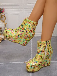 Detail view of yellow platform wedge ankle boots with colorful shimmering pattern