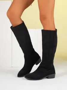 Side view of black faux suede knee-high boots with block heel and rounded toe design
