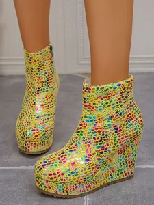 Detailed view of yellow platform wedge boots with vibrant colorful patterns and zip