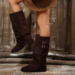Close-up view of brown suede pant-leg shoveler boots with stylish metal buckle details.