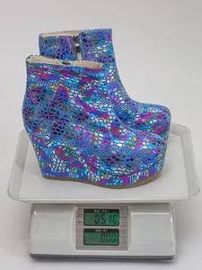 Detail showing colorful wedge platform boots weighing 0.51kg on a professional digital scale
