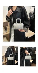 Nahaufnahme einer hellgrauen geflochtenen Boston-Tasche mit Details zu Textur und Griffen