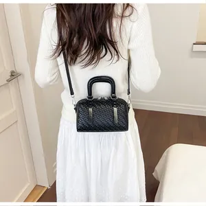 Rückansicht einer stilvollen Frau mit einer schwarzen gewebten Boston-Handtasche