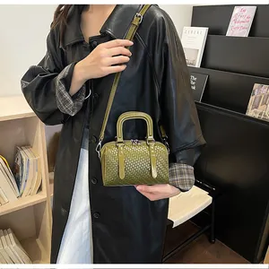 Grüne gewebte Boston-Handtasche, getragen von einem Modell in stilvoller Innenumgebung