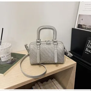 Nahaufnahme einer grauen gewebten Boston-Handtasche mit Griffen und Schultergurt