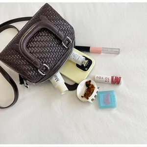 Detailansicht der geräumigen Innenseite einer braunen Boston-Handtasche mit Lifestyle-Artikeln