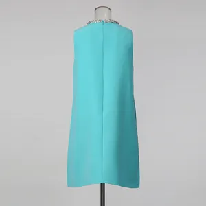 Close-up detail of a blue sleeveless straight dress with sparkling rhinestone neckline.