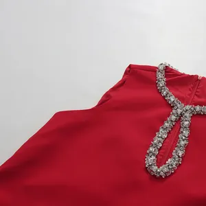 Close-up detail of a red sleeveless dress featuring a luxurious rhinestone neckline.