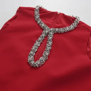 Detailed view of the elegant red sleeveless dress with a luxurious rhinestone neckline.