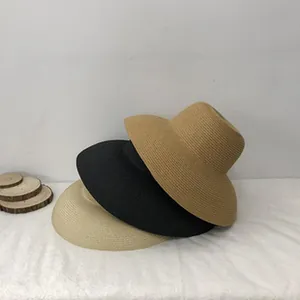 Detail view of woven raffia sun hats in khaki, black, and beige colors