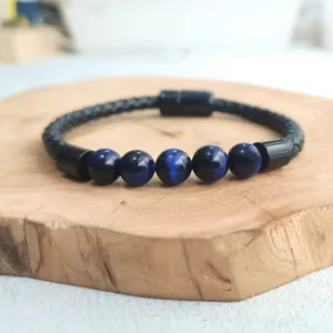 Nahaufnahme der blauen Tigeraugenperlen am schwarzen geflochtenen Lederarmband für Herren