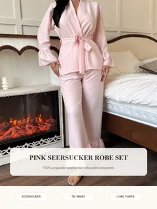 Detail eines rosa Seersucker-Bademantel-Sets mit langer Hose in einem Schlafzimmer