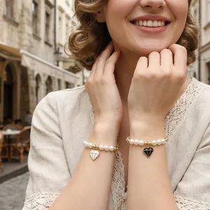 Gros plan de bracelets en perles avec pendentifs diamant noir et blanc sur un modèle