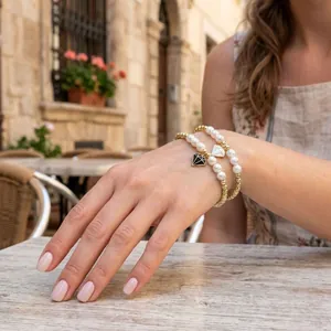 Détail de bracelets de perles dorées minimalistes avec perles et breloques en diamant