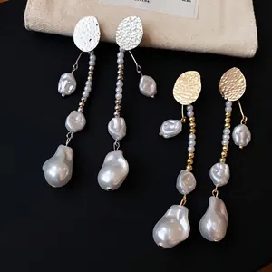 Elegant vintage-style long drop earrings with baroque pearls and hammered metal discs.