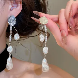 Détail de boucles d'oreilles vintage en argent plissé avec perles baroques élégantes