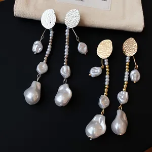 Vue détaillée de boucles d'oreilles en perles baroques rétro avec disques d'or et d'argent