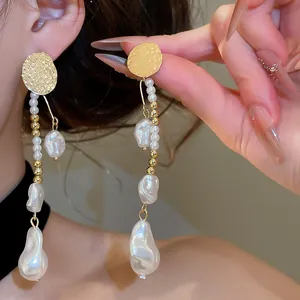 Vue détaillée des boucles d'oreilles rétro dorées avec de longues perles élégantes