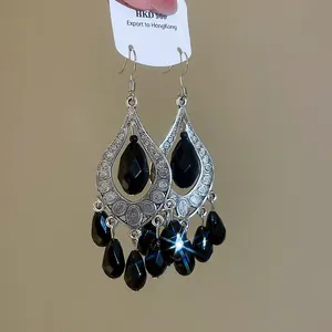 Detail of vintage court style teardrop earrings with faceted black beads and silver tassels