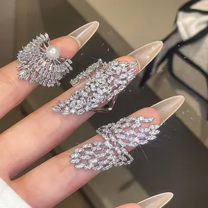 Gros plan de bagues ouvertes en zircon et perles étincelantes au design géométrique luxe