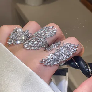 Vue détaillée de bagues en zircon étincelant avec perle sur une main, textures de luxe.