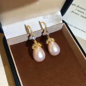 Detailopname van elegante roze pareloorbellen met 18k vergulde zirkoon haken in een doosje