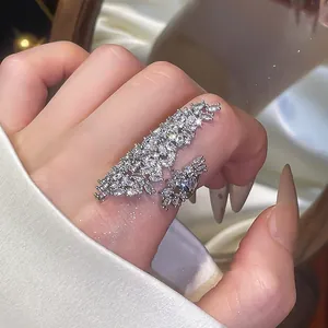 Gros plan détaillé sur l'amas de zircons étincelants d'une bague ouverte argentée