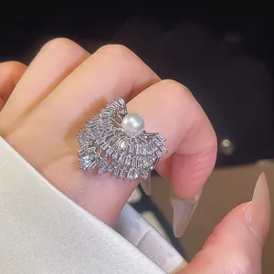 Gros plan détaillé d'une bague géométrique de luxe ornée de zircons et d'une perle blanche