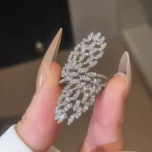 Détail macro d'une bague étincelante en forme d'aile argentée avec des zircons cubiques