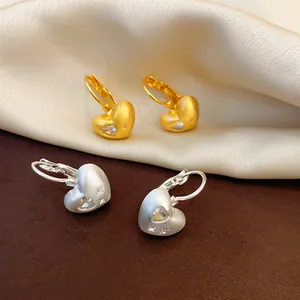 Macro view of elegant matte heart-shaped leverback earrings with zircon and star patterns