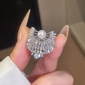 Détail macro d'une bague ouverte géométrique étincelante avec zircon et perle de luxe