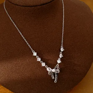 Elegante silberne Schleifenkette mit funkelnden Zirkonia und einer weißen Perle.