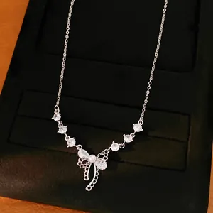 Elegante silberfarbene Halskette mit einem zirkonia-besetzten Schleifenanhänger und Perle.