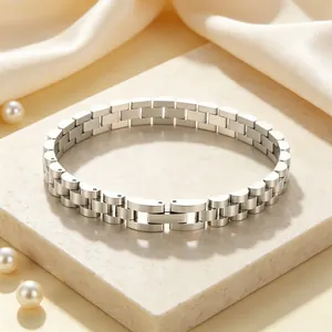 Close-up of stainless steel watch-band style bracelet on stone base with pearls