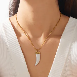 Close-up of vintage white horn pendant necklace with gold-plated bead chain on model
