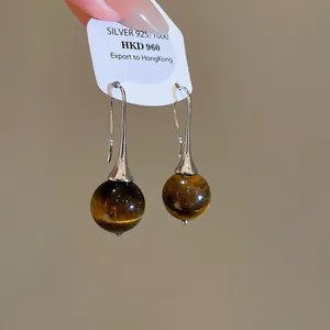 Detailed view of vintage tiger eye stone sphere drop earrings with silver 925 hooks