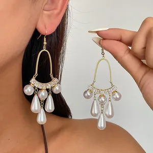 Detailansicht von Vintage-Gold-Kronleuchter-Ohrringen mit Tropfenperlen und Zirkonien.