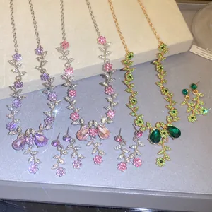 Detailed view of elegant floral rhinestone necklace and earring sets in purple pink and green
