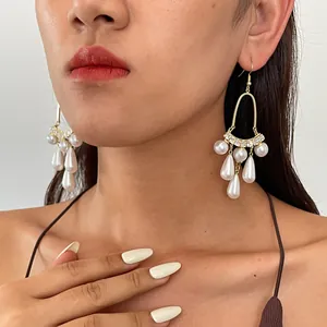 Detailaufnahme von Retro-Ohrringen mit Perlen, Zirkonia und Wassertropfen-Quasten.