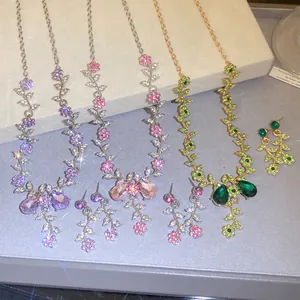 Detailed view of floral rhinestone jewelry sets in purple, pink and green for brides.
