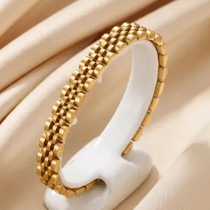Detailopname van een goudkleurige roestvrijstalen horlogebandarmband op een standaard.