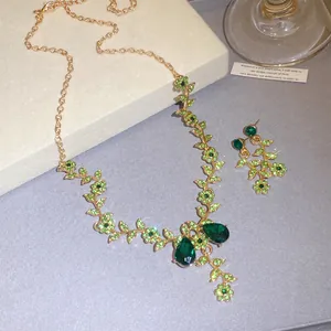 Elegant green floral jewelry set with emerald-colored crystal necklace and earrings.