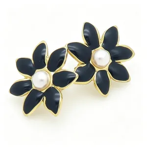 Boucles d'oreilles vintage en émail noir en forme de fleur avec perle centrale chic.