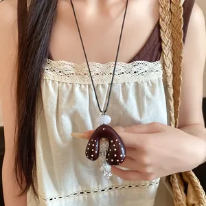 Detailweergave van de boho halsketting met gestipte hartvormige hanger en kwastjes