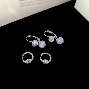 Close-up of elegant silver earrings set with sparkling geometric and round zircons