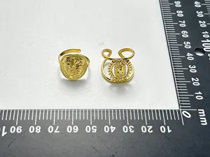 Nahaufnahme von 18K vergoldeten Maria und Römischen Münzringen auf einer Messskala
