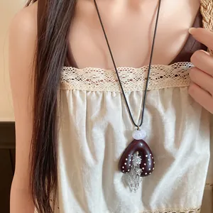 Detail van de boheemse hartketting met witte stippen en fonkelende kristallen kwastjes