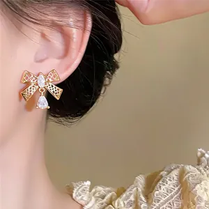 Detailopname van elegante 18k vergulde strikoorbellen met schitterende zirkonia's