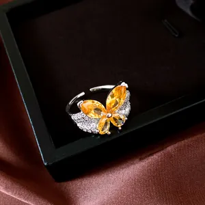Macro detail of silver butterfly ring with vibrant orange teardrop zircon stones